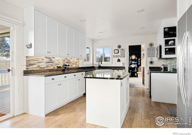 5072 Saint Andrews Dr, Loveland, CO 80537 - kitchen with light wood-style floors, dark countertops, white cabinetry, a center island, and recessed lighting