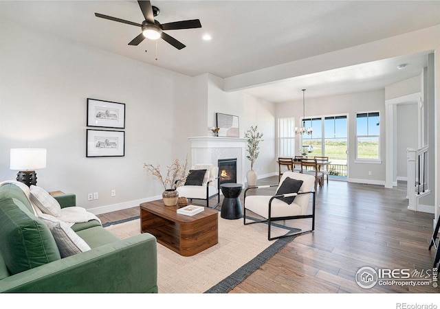 1550 Harebell St, Berthoud, CO 80513 - living area featuring a glass covered fireplace, wood finished floors, a chandelier, ceiling fan, and recessed lighting