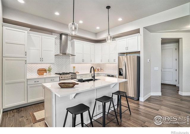 1550 Harebell St, Berthoud, CO 80513 - kitchen with stainless steel appliances, wall chimney exhaust hood, dark wood-style flooring, tasteful backsplash, and white cabinets