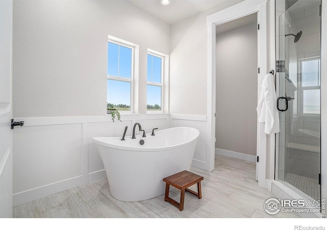 1550 Harebell St, Berthoud, CO 80513 - bathroom with a stall shower, a freestanding bath, a decorative wall, wainscoting, and recessed lighting