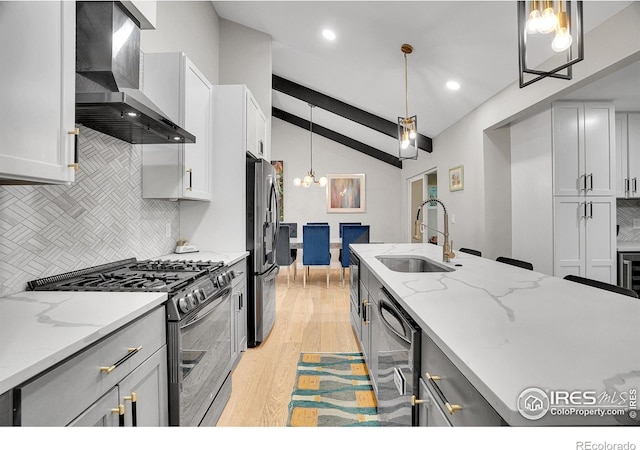 7146 Petursdale Ct, Boulder, CO 80301 - kitchen featuring appliances with stainless steel finishes, wall chimney exhaust hood, backsplash, light wood-style floors, and pendant lighting