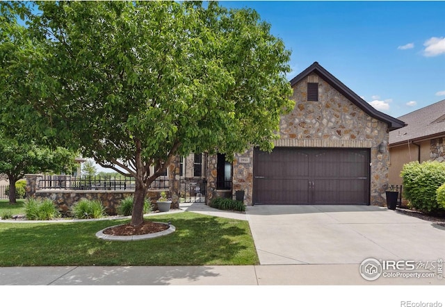 2055 Vineyard Dr, Windsor, CO 80550 - view of front of home featuring stone siding, an attached garage, and driveway