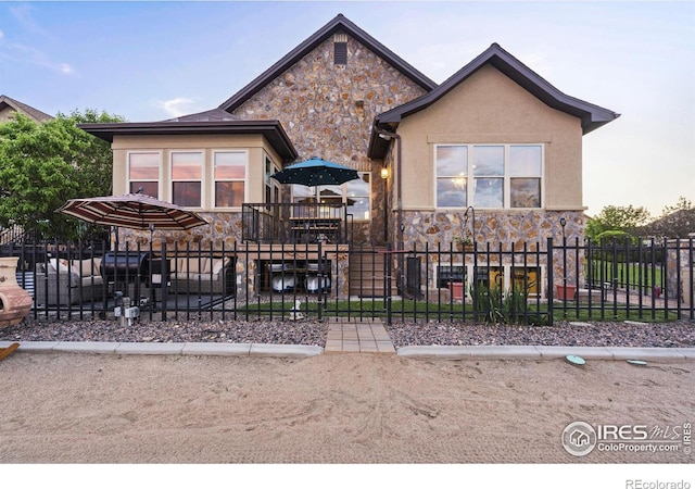 2055 Vineyard Dr, Windsor, CO 80550 - view of front of home with stone siding, a fenced front yard, and stucco siding