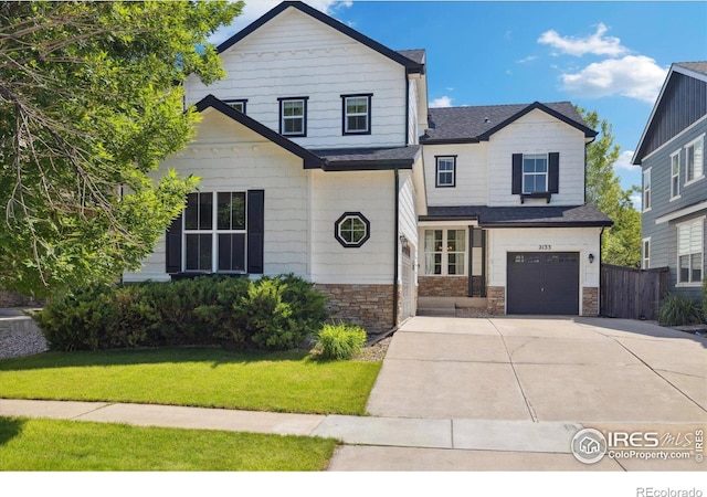 2133 Katahdin Dr, Fort Collins, CO 80525 - view of front facade with concrete driveway, stone siding, and a garage