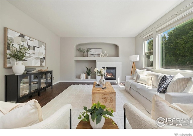 2133 Katahdin Dr, Fort Collins, CO 80525 - living area featuring wood finished floors, a glass covered fireplace, and built in shelves