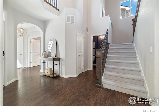 2133 Katahdin Dr, Fort Collins, CO 80525 - stairs featuring a high ceiling, wood finished floors, and arched walkways
