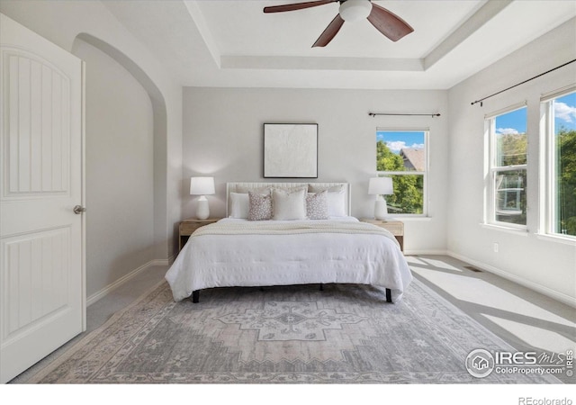 2133 Katahdin Dr, Fort Collins, CO 80525 - bedroom featuring a tray ceiling, arched walkways, and a ceiling fan