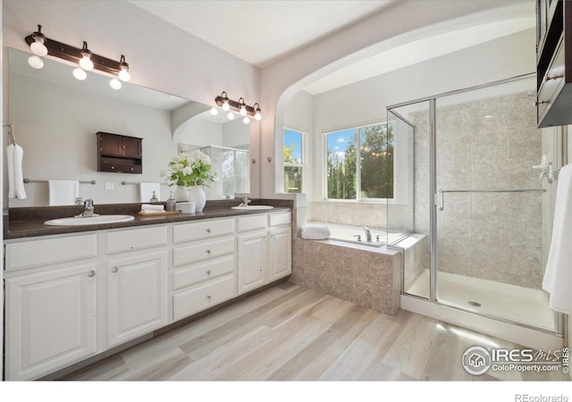 2133 Katahdin Dr, Fort Collins, CO 80525 - bathroom featuring a bath, a shower stall, double vanity, and wood finished floors