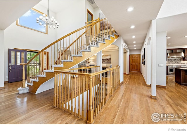 14601 Akron St, Brighton, CO 80602 - stairs featuring wood finished floors, recessed lighting, a chandelier, and a towering ceiling