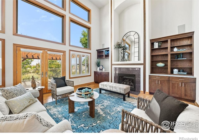14601 Akron St, Brighton, CO 80602 - living room with a high ceiling, a fireplace, wood finished floors, and french doors
