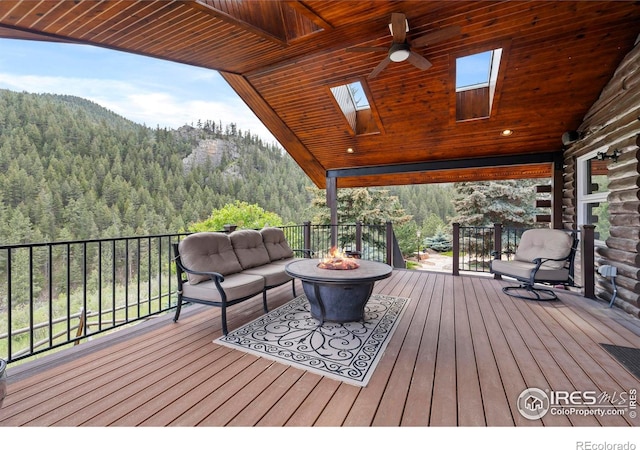 164 Dunraven Glade Rd, Glen Haven, CO 80532 - deck with a wooded view, a fire pit, and a mountain view