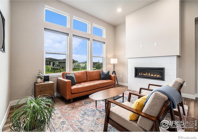 2716 San Cristobal Ct, Timnath, CO 80547 - living area with a tiled fireplace, wood finished floors, healthy amount of natural light, and recessed lighting