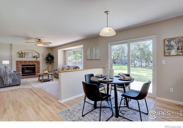 13382 Franklin St, Thornton, CO 80241 - dining room with light wood-type flooring, ceiling fan, and a fireplace