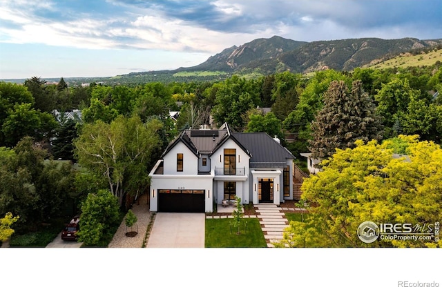 640 Iris Ave, Boulder, CO 80304 - view of front of house featuring an attached garage, driveway, stucco siding, a mountain view, and solar panels