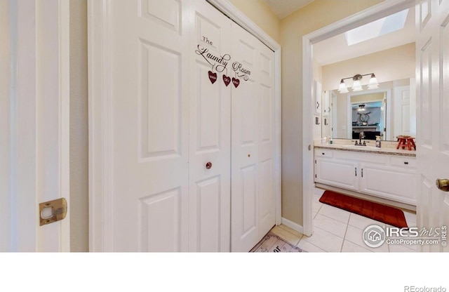 4557 W Pioneer Ln, Greeley, CO 80634 - bathroom with tile patterned flooring, vanity, a skylight, and a closet