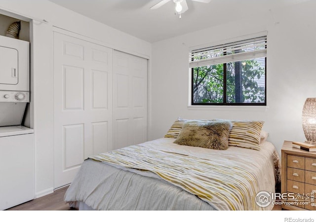 910 Portland Pl Unit 7, Boulder, CO 80304 - bedroom featuring stacked washing machine and dryer, a closet, wood finished floors, and a ceiling fan