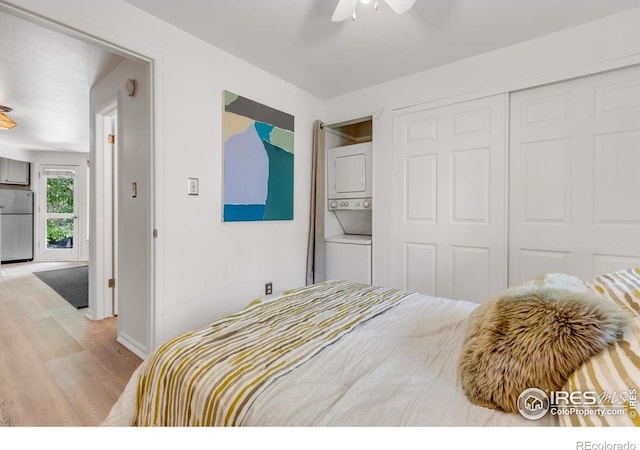 910 Portland Pl Unit 7, Boulder, CO 80304 - bedroom featuring stacked washing machine and dryer, freestanding refrigerator, light wood-style floors, a closet, and ceiling fan