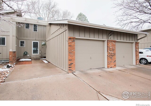 3025 Regatta Ln Unit 3, Fort Collins, CO 80525 - view of front of house featuring brick siding, concrete driveway, an attached garage, and board and batten siding