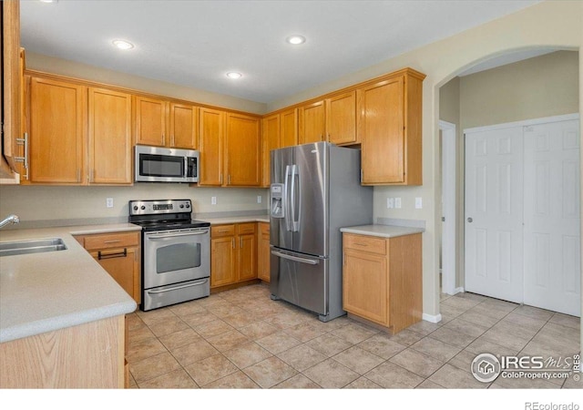 17216 E Trailmaster Dr, Parker, CO 80134 - kitchen with appliances with stainless steel finishes, light countertops, arched walkways, recessed lighting, and light tile patterned floors