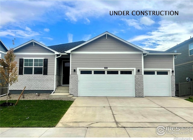 1885 Mount Monroe Dr, Berthoud, CO 80513 - view of front facade with a garage, concrete driveway, brick siding, and a front lawn