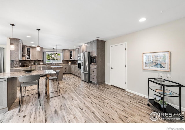 40 Walter Way, Broomfield, CO 80020 - kitchen with stainless steel appliances, recessed lighting, a peninsula, tasteful backsplash, and a kitchen breakfast bar
