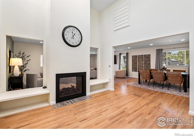 40 Walter Way, Broomfield, CO 80020 - living area featuring wood finished floors, a high ceiling, and a multi sided fireplace