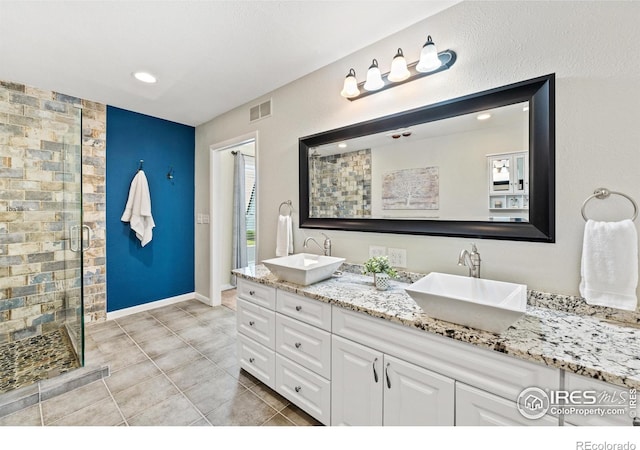 40 Walter Way, Broomfield, CO 80020 - bathroom with a shower stall, double vanity, tile patterned flooring, and recessed lighting
