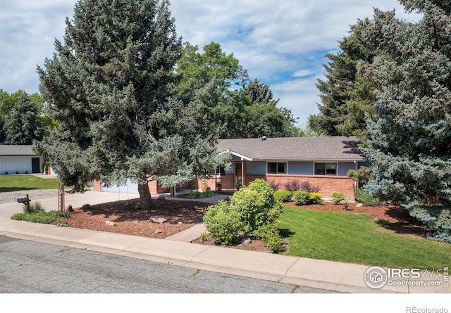 7459 Mount Meeker Rd, Longmont, CO 80503 - view of front of home with driveway, a front lawn, brick siding, and an attached garage