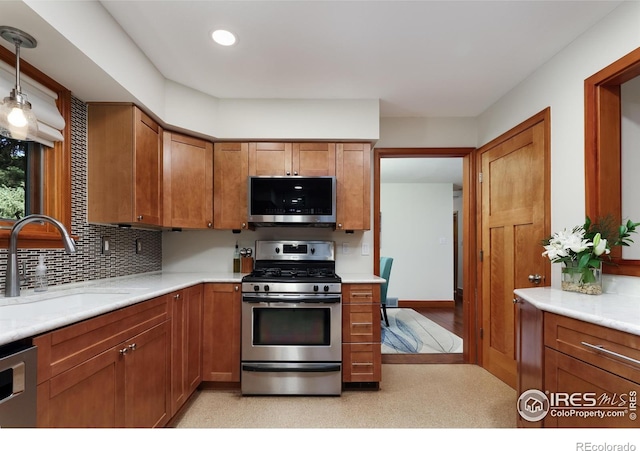 7459 Mount Meeker Rd, Longmont, CO 80503 - kitchen featuring appliances with stainless steel finishes, brown cabinetry, light countertops, and recessed lighting