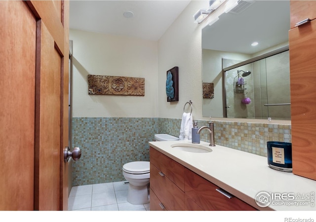 7459 Mount Meeker Rd, Longmont, CO 80503 - full bath featuring vanity, tile walls, tile patterned floors, a shower stall, and wainscoting