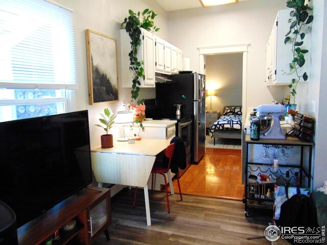 2205 Arapahoe Ave Unit 3, Boulder, CO 80302 - kitchen featuring dark wood-style flooring, white cabinetry, light countertops, and freestanding refrigerator