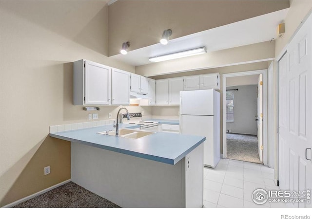3565 Windmill Dr Unit F-7, Fort Collins, CO 80526 - kitchen featuring white appliances, a peninsula, under cabinet range hood, light countertops, and white cabinetry
