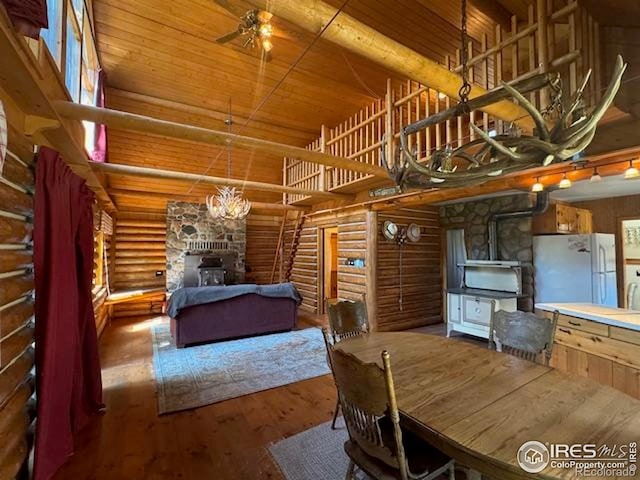 110 Meadow Ln, Bellvue, CO 80512 - dining space featuring log walls, wood finished floors, wooden ceiling, a high ceiling, and a chandelier
