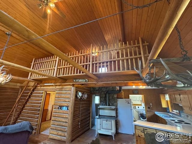 110 Meadow Ln, Bellvue, CO 80512 - kitchen with freestanding refrigerator, a high ceiling, washer / clothes dryer, rustic walls, and ceiling fan