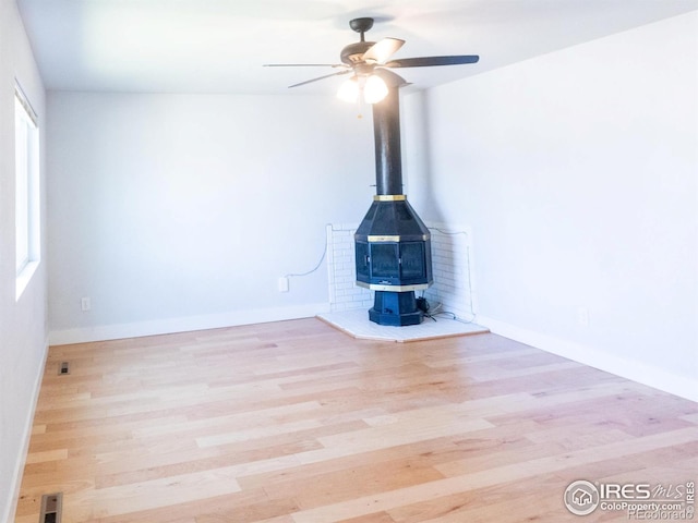 2037 Wedgewood Ct, Greeley, CO 80631 - unfurnished living room with a wood stove, a ceiling fan, and wood finished floors