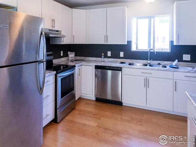 2037 Wedgewood Ct, Greeley, CO 80631 - kitchen featuring appliances with stainless steel finishes, under cabinet range hood, light wood finished floors, and white cabinets