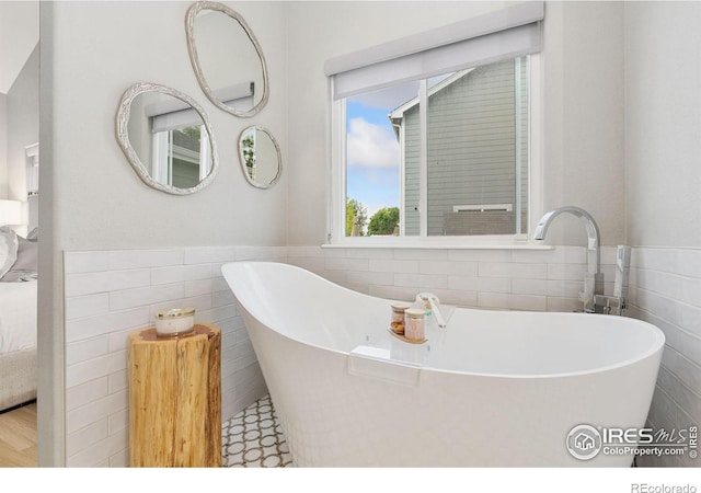 641 Babine Ct, Windsor, CO 80550 - full bathroom with tile walls, a soaking tub, wainscoting, and connected bathroom