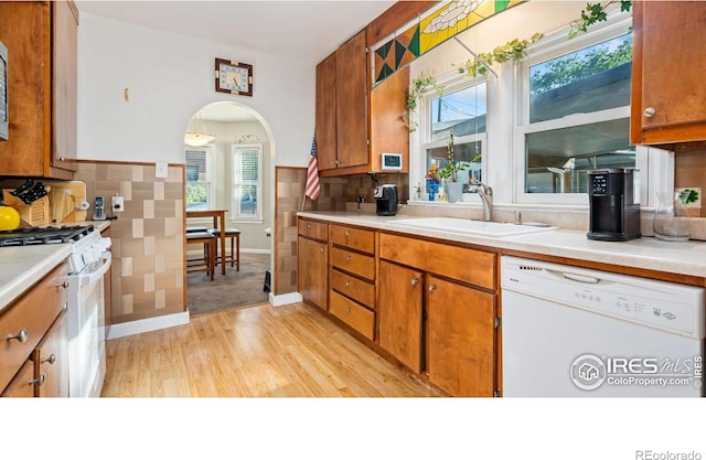 1817 15th Ave, Greeley, CO 80631 - kitchen featuring white appliances, arched walkways, light countertops, and tasteful backsplash