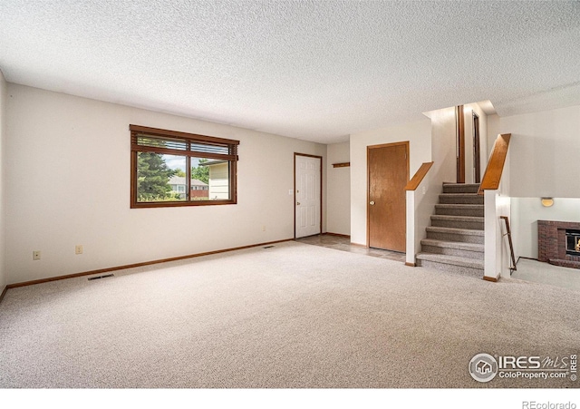 837 Arbor Ave, Fort Collins, CO 80526 - unfurnished living room featuring carpet, a fireplace, stairway, and a textured ceiling
