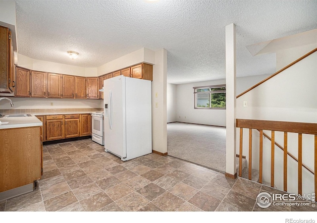 837 Arbor Ave, Fort Collins, CO 80526 - kitchen with white appliances, brown cabinets, light countertops, a textured ceiling, and light colored carpet