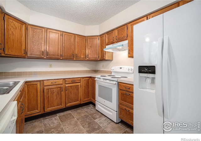837 Arbor Ave, Fort Collins, CO 80526 - kitchen featuring white appliances, under cabinet range hood, a textured ceiling, brown cabinets, and light countertops