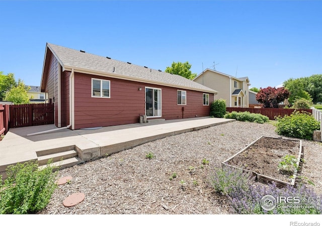 2217 Waylon Dr, Johnstown, CO 80534 - rear view of property featuring a patio, a fenced backyard, and a vegetable garden