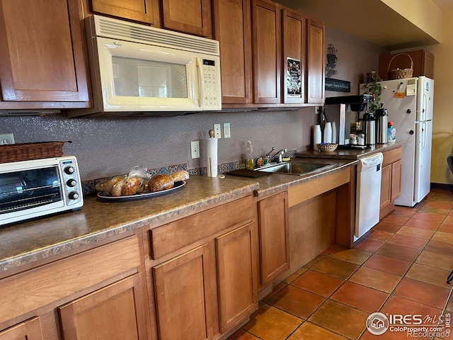 1238 Finch St, Loveland, CO 80537 - kitchen featuring white appliances, dark tile patterned flooring, brown cabinetry, and dark countertops