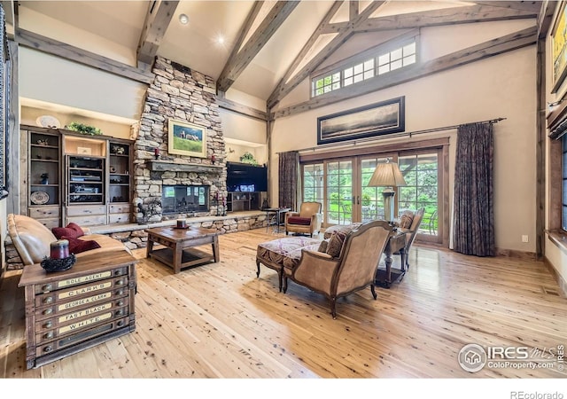 8576 Niwot Meadow Farm Rd, Niwot, CO 80503 - living area featuring hardwood / wood-style floors, high vaulted ceiling, beam ceiling, and a stone fireplace