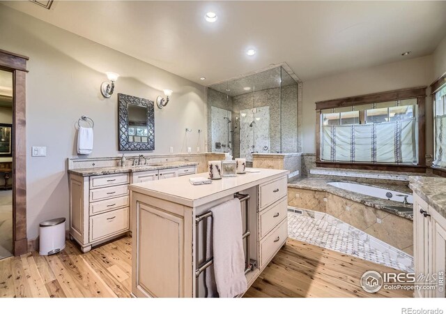 8576 Niwot Meadow Farm Rd, Niwot, CO 80503 - bathroom with wood finished floors, vanity, a garden tub, a stall shower, and recessed lighting
