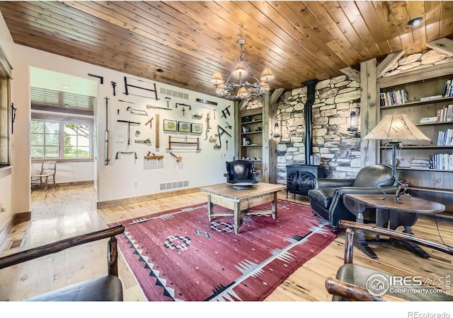 8576 Niwot Meadow Farm Rd, Niwot, CO 80503 - living room featuring wood-type flooring, a wood stove, a chandelier, wooden ceiling, and built in features