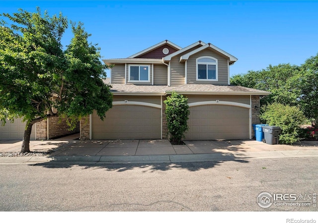 702 Cairnes Dr Unit B4, Fort Collins, CO 80524 - view of front of property featuring a garage, stone siding, and roof with shingles
