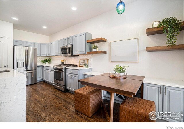 702 Cairnes Dr Unit B4, Fort Collins, CO 80524 - kitchen with gray cabinetry, stainless steel appliances, open shelves, dark wood-style floors, and tasteful backsplash