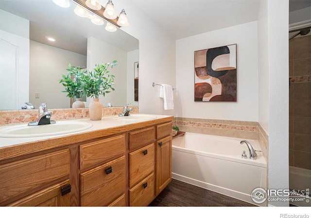 702 Cairnes Dr Unit B4, Fort Collins, CO 80524 - bathroom featuring double vanity, a garden tub, and wood finished floors