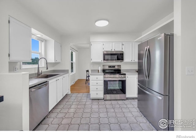 2036 Lexington Ct, Fort Collins, CO 80526 - kitchen with appliances with stainless steel finishes, light floors, light countertops, and white cabinets